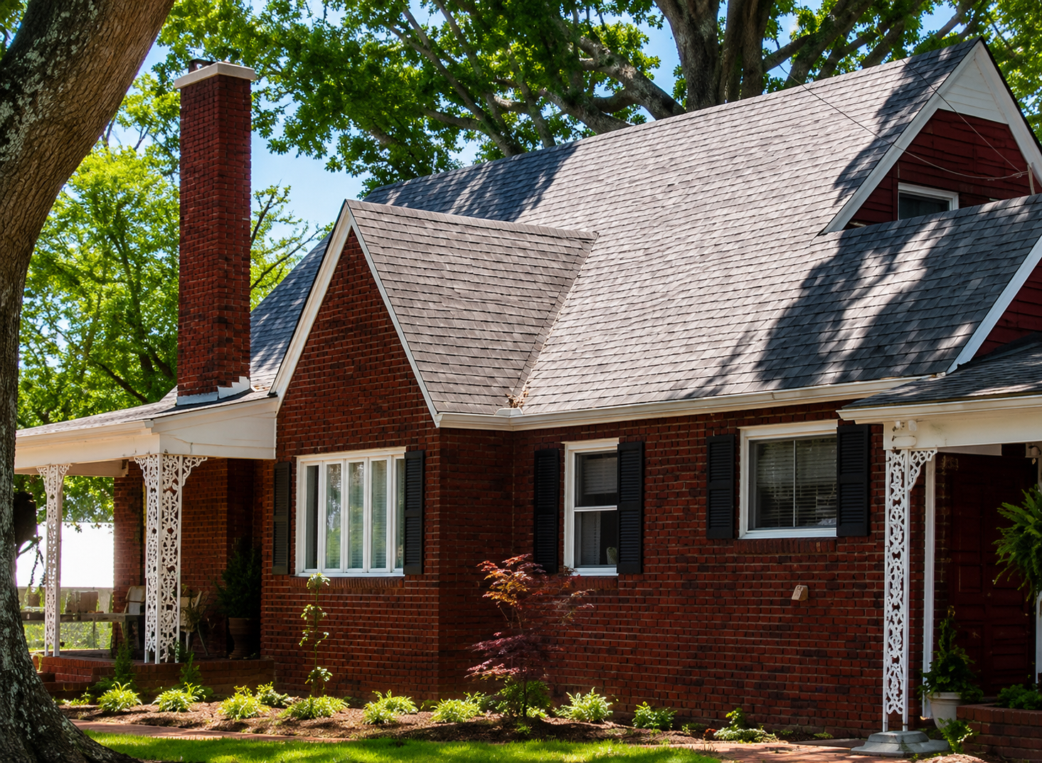 A charming brick inn with white porch trim nestled among trees