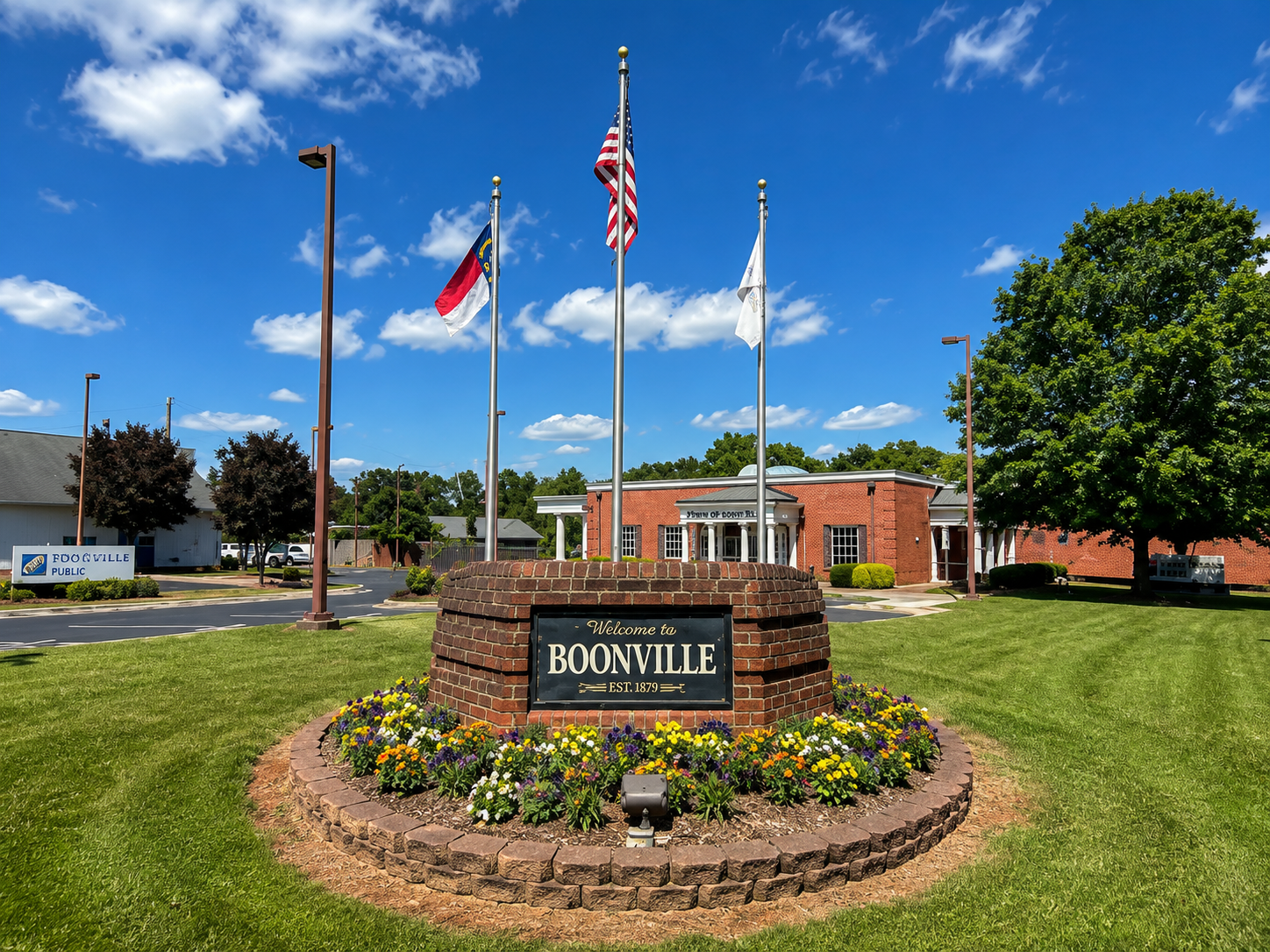 Welcome to Boonville sign in front of Town Hall with American, North Carolina, and town flags
