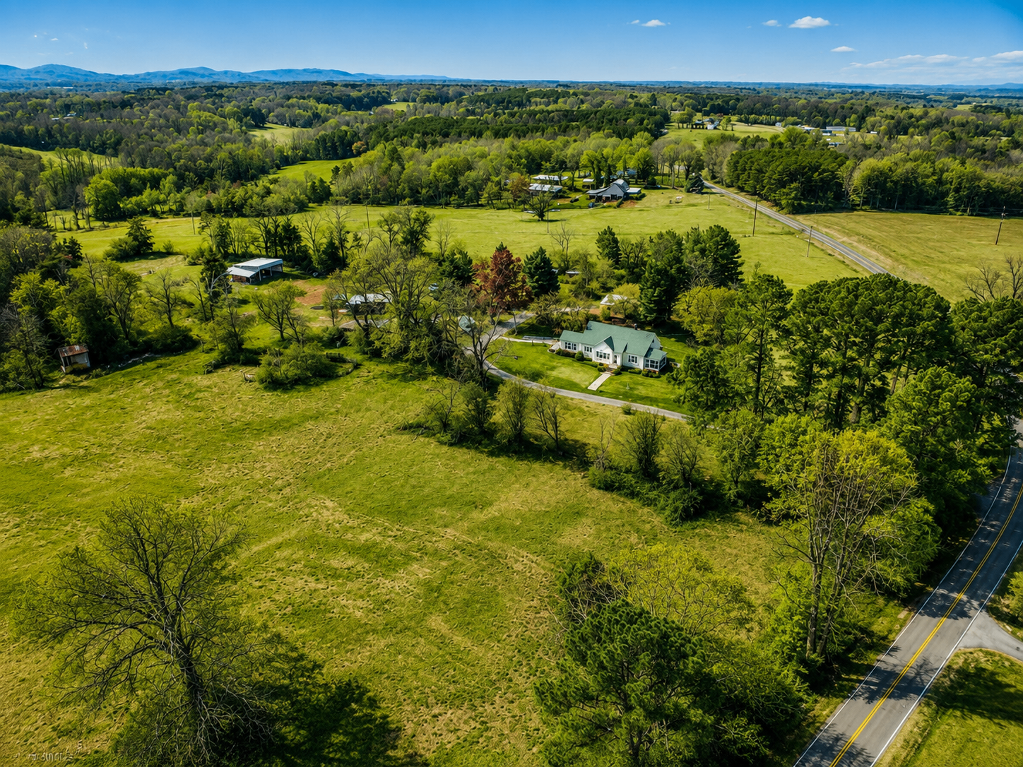 Aerial view of green farmland and a country home in the Yadkin Valley